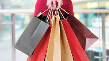 woman in red dress holding shopping bags
